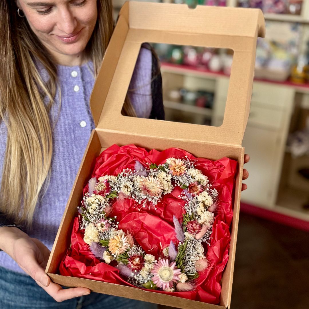Primo piano ghirlanda di fiori secchi a forma di cuore nella confezione originale