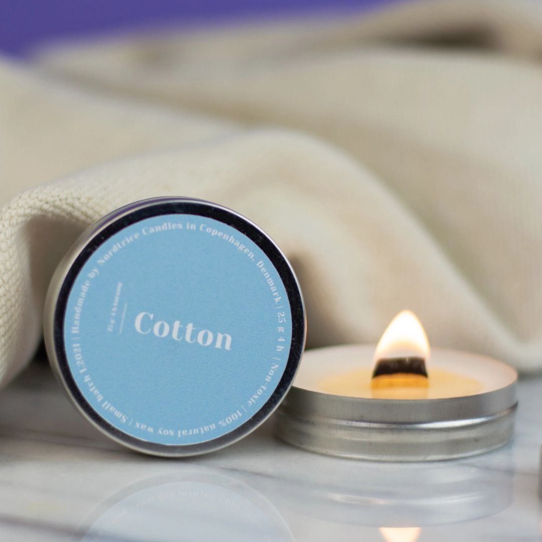 Candela Nortrice accesa su fondo chiaro, fragranza francese intensa.