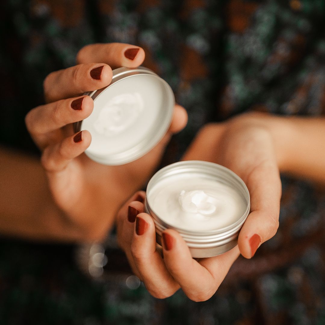 dettaglio di mani che aprono la confezione di una crema naturale 